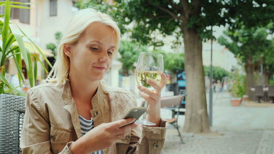 女人喝酒和使用智能手机视频素材模板下载