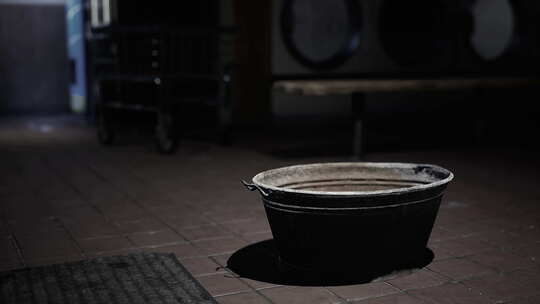 黑暗房间里坐在地上的水桶