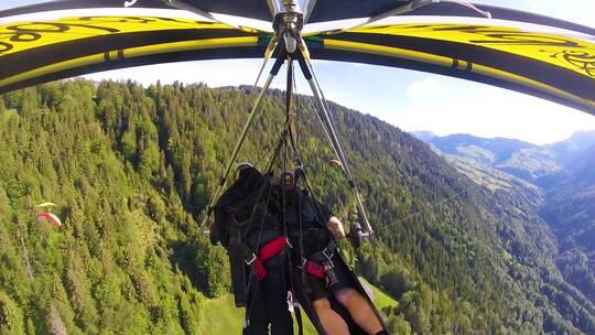 航拍滑翔伞飞越瑞士阿尔卑斯山和村庄视频素材模板下载