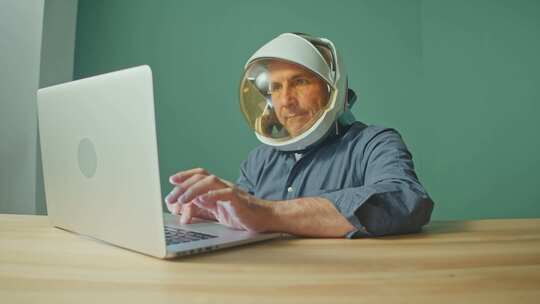 男人戴着太空头盔使用电脑