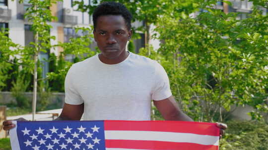 夏天拿着美国国旗和相机的肖像非裔美国人