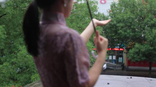 下雨场景，旗袍女孩打伞撑在雨中，雨滴落下