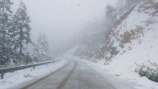 高山公路的雪花纷飞与车轮印