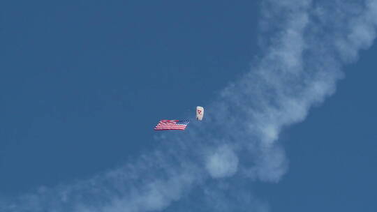 跳伞运动员降下时悬挂着美国国旗