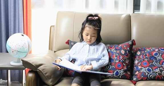 女孩坐沙发上看书