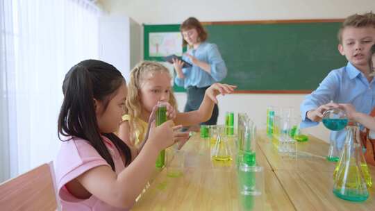 可爱的学生在小学教室里和老师一起学习。