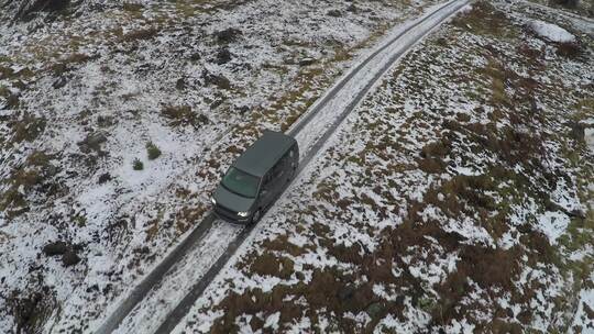 黑色货车沿着积雪覆盖的道路天线行驶