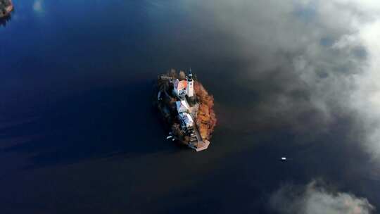相机飞过布莱德湖岛，当它平移到岛上和一艘传统的plenta船上时视频素材模板下载