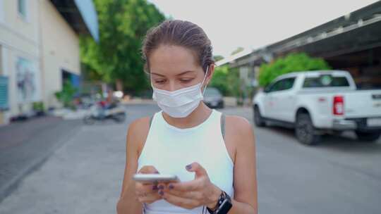 戴口罩的女人用手机直视相机