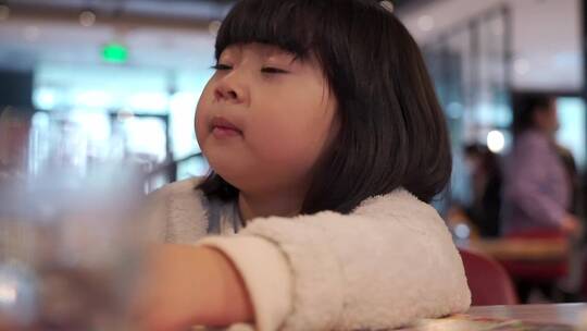 在餐厅喝水的亚洲女孩视频素材模板下载