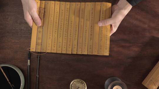 古代文人打开竹简学习中国传统文学论语