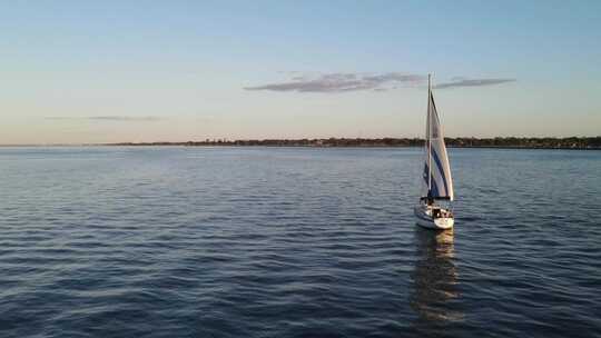 美国路易斯安那州新奥尔良日落时分，飞越海洋和美丽的帆船。-空中德龙