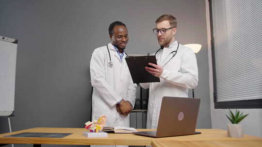 Lab Coats的两名医生分析平板电脑