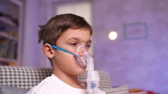 喷雾器吸入器口罩中的肖像男孩以蒸汽的形式