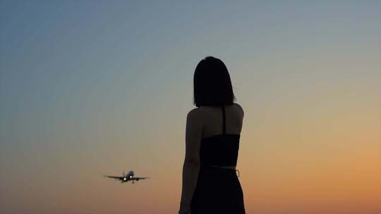 日落黄昏机场美女看向飞机降落
