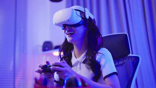 亚洲年轻的电子竞技女玩家使用科技VR眼镜玩游戏。