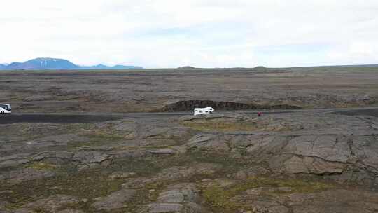 位于冰岛熔岩场的休闲车和旅游巴士，无人机视频向前移动