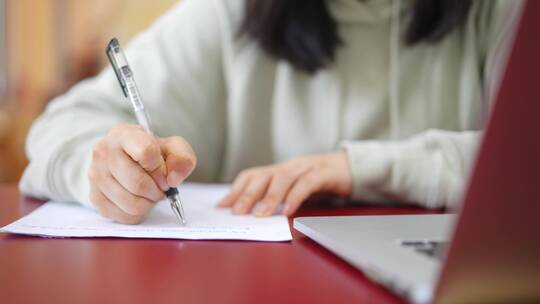 年轻女子在图书馆使用笔记本电脑上网学习