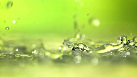 水滴飞溅在绿色背景上的表面
