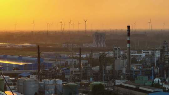 航拍城市日落时的风力新能源和石化工厂