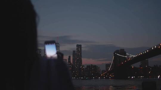 女人用智能手机拍摄夜景