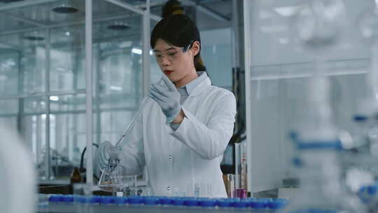 中国女化学家向烧瓶中的液体中添加试剂并搅