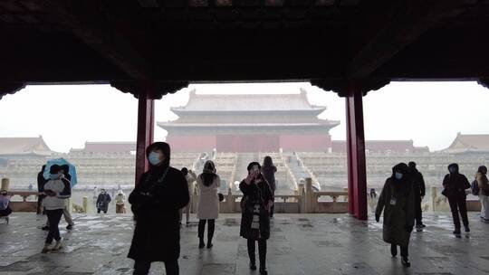 故宫宫殿下雪拍照的游客