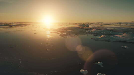 南极洲橙色日落太阳眩光史诗鸟瞰无人机飞行