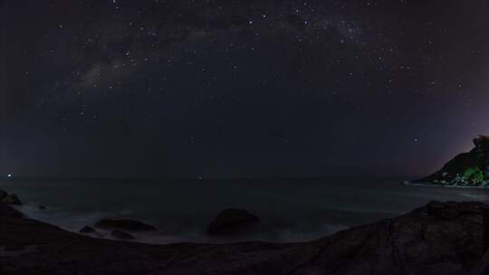 从岩石海岸延时看到银河星夜