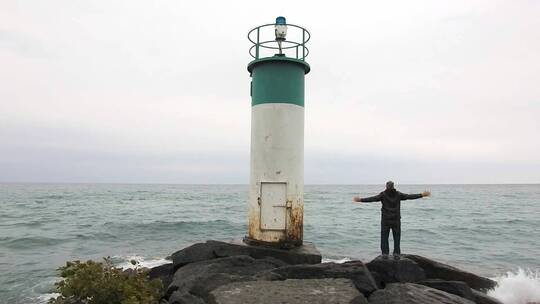 欣赏海浪拍打海岸风景的男人