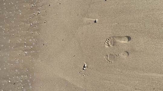 海浪冲走沙滩上的两个脚印视频素材模板下载