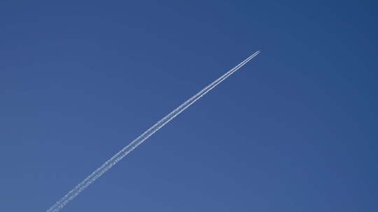 飞机飞过蓝天，留下唯美尾流