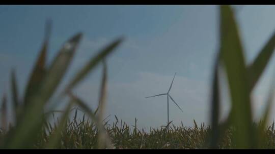 在蓝天绿草的背景下旋转风车。风力视频素材模板下载