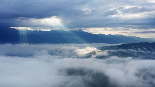 清晨的太阳光透过云层打在山川云雾之上