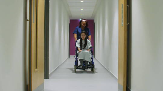 女护士推轮椅上的病人视频素材模板下载
