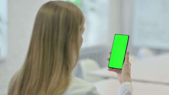 女人看着绿屏幕的手机