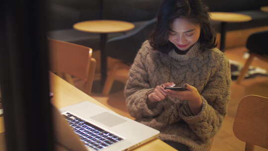 城市白领夜晚咖啡馆办公用电脑看手机发消息