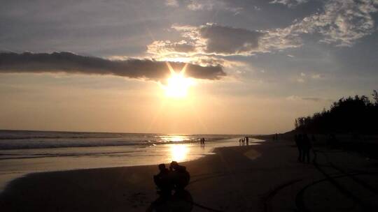 夕阳时刻海滩上人们的剪影