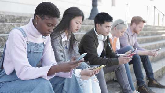 年轻人坐在户外用手机放松视频素材模板下载