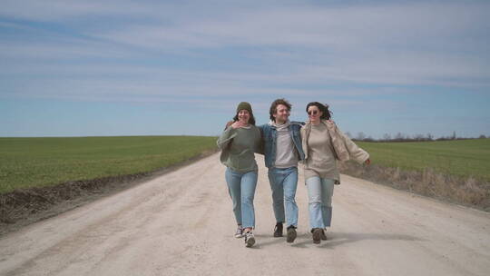 三个人走在田野间的小路上