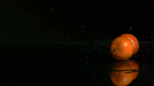 橘子在黑色的水面上弹跳