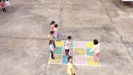 小孩在户外场地玩跳房子游戏