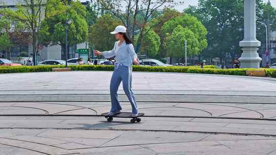 一名年轻美少女在公园广场独自一人练习滑板