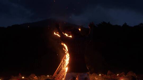 一个人站在燃烧的火堆前