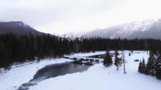 航拍新疆冬季喀纳斯湖雪景雪山森林冰河晨雾