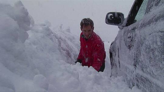 男人在暴风雪中挖出了他的车