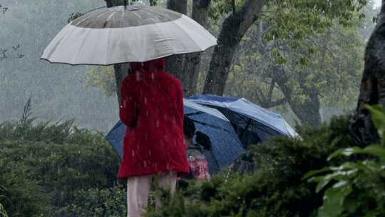 三个孩子拿着雨伞在雨中跳上跳下