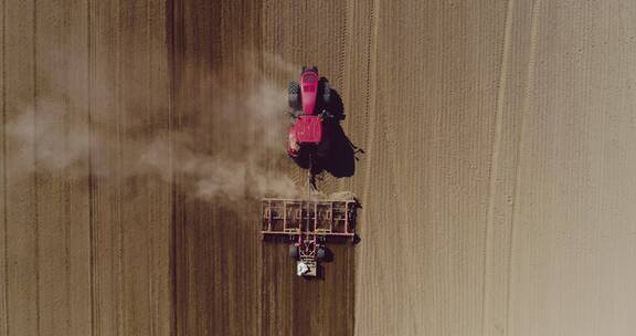 拖拉机在收获田里耕作农田