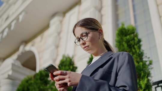 年轻职业女性在城市环境中使用智能手机
