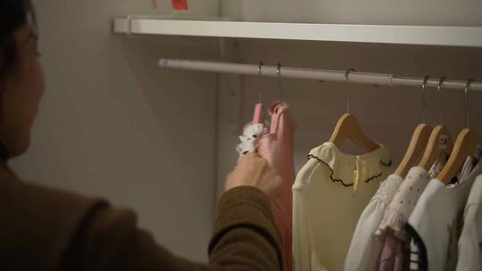 中年女性在服装店衣柜选择衣服